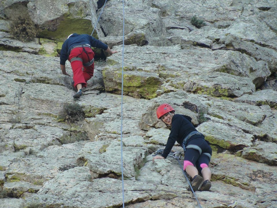 Escalada en la roca, con una participante mirando hacia abajo
